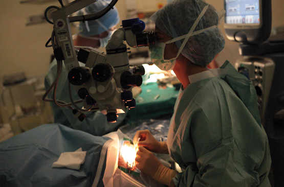 Le chirurgien regarde à travers un microscope l’œil qu’il opère
