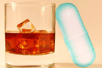 Médicament posé contre un verre d'alcool