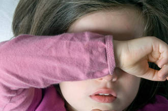 Enfant protégeant du bras son visage