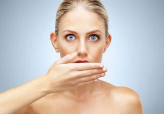 Femme avec la main devant la bouche