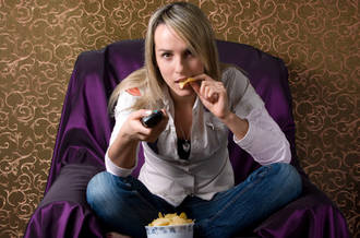 Adolescente mangeant en regardant la TV