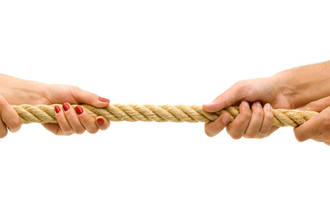 Mains féminines tirant la corde à des mains masculines