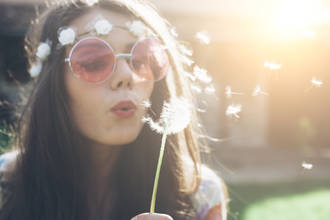 Hippie jeune femme souffle pissenlit à l'extérieur