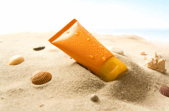 Tube de crème solaire sur le sable